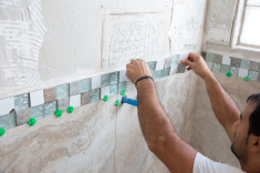 stock-photo-80422033-tile-series-tile-border-being-installed-on-shower-wall-in-home